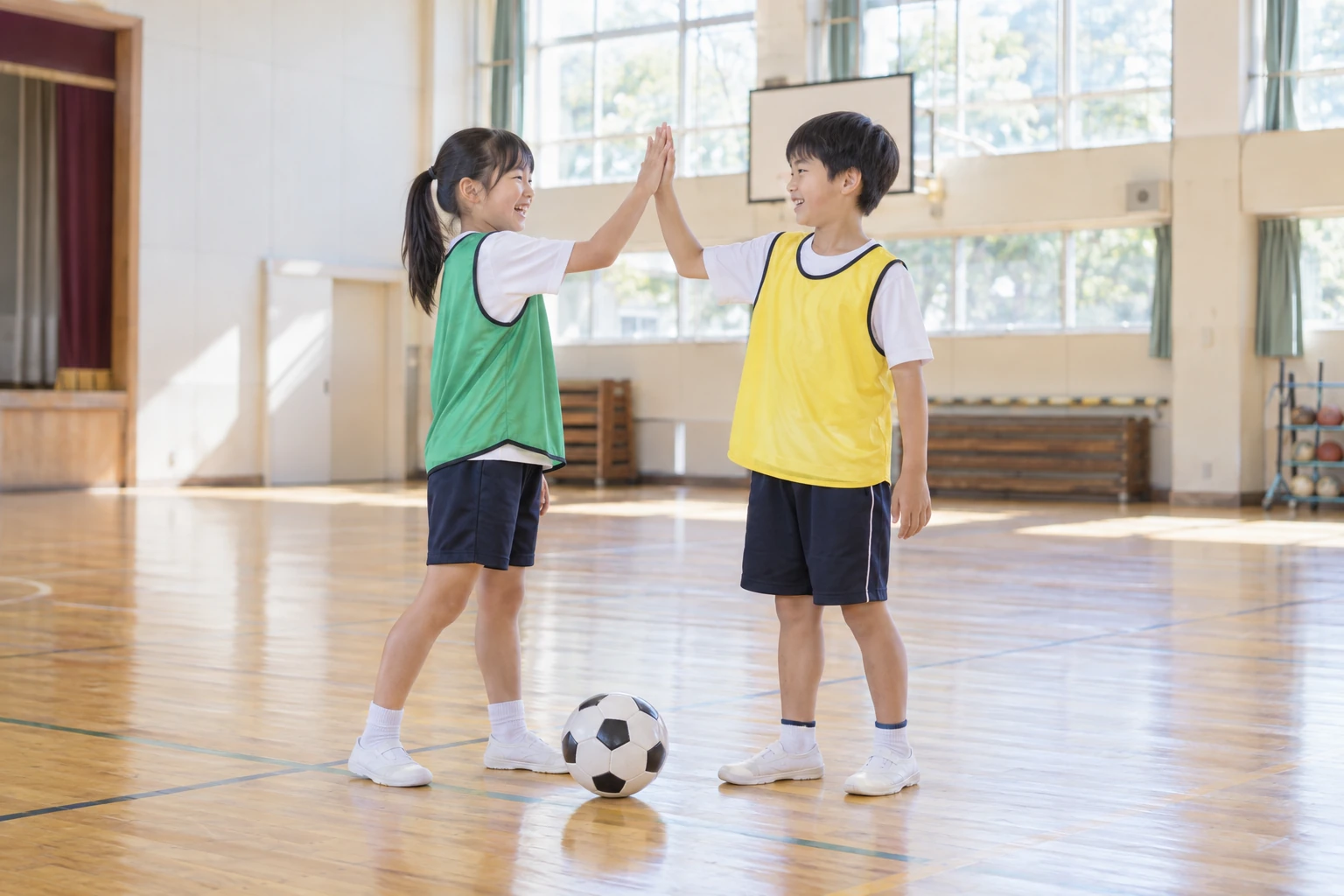 仲間とハイタッチをする子どもたちのイメージ